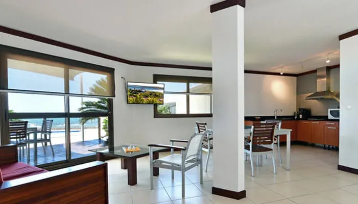 Séjour et kitchenette de la Suite Corail ouverts sur le lagon
